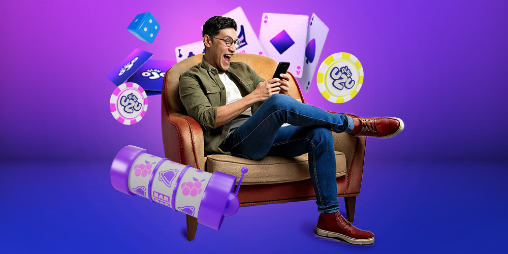 Hombre joven sentado en un sillón entretenido en su teléfono jugando en PlayUZU.